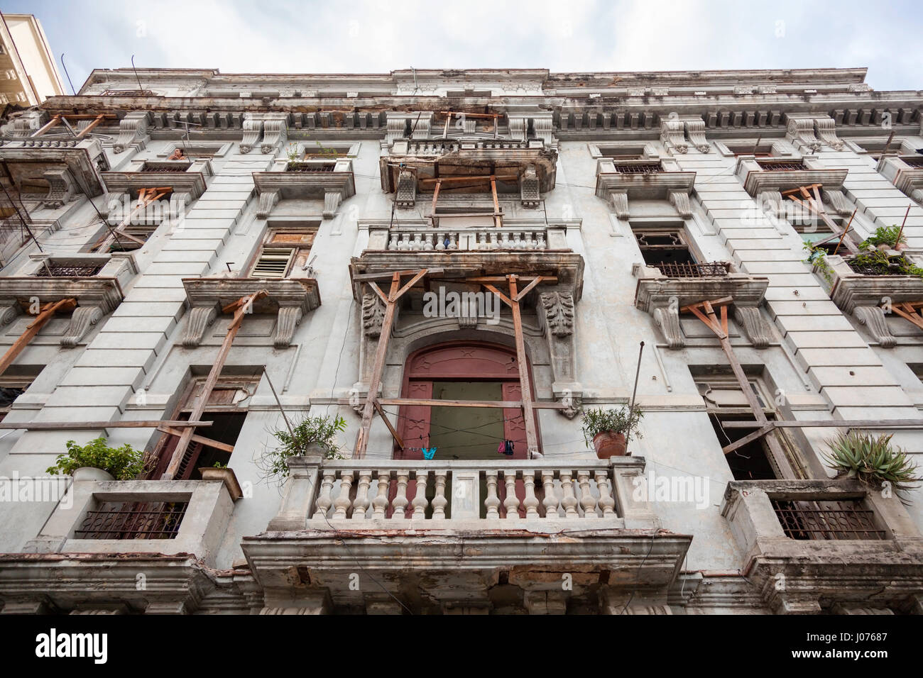 Il balcone di ogni camera essendo stabilizzata da travetti di legno su un decrepito edificio di appartamenti in Old Havana, Cuba. Foto Stock
