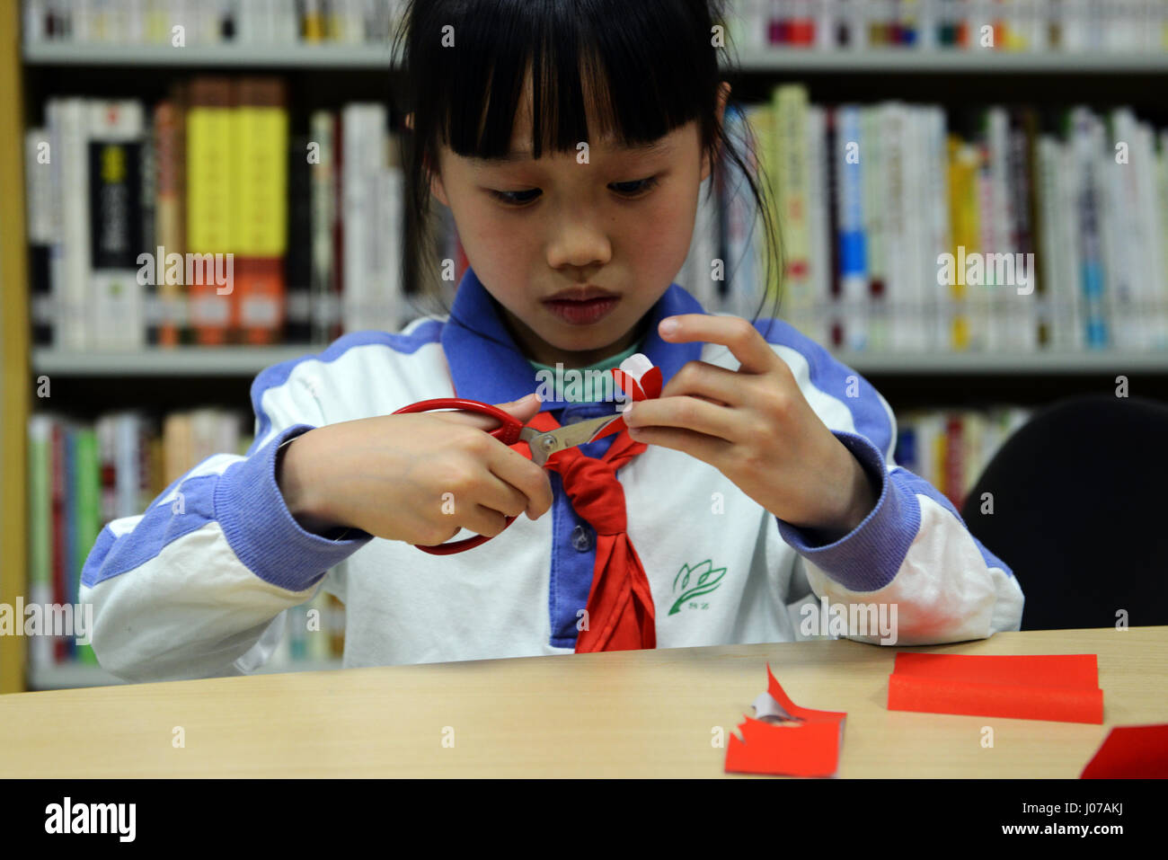 Bambini imparare l arte del Jianzhi- Cinese tradizionale taglio della carta. Foto Stock