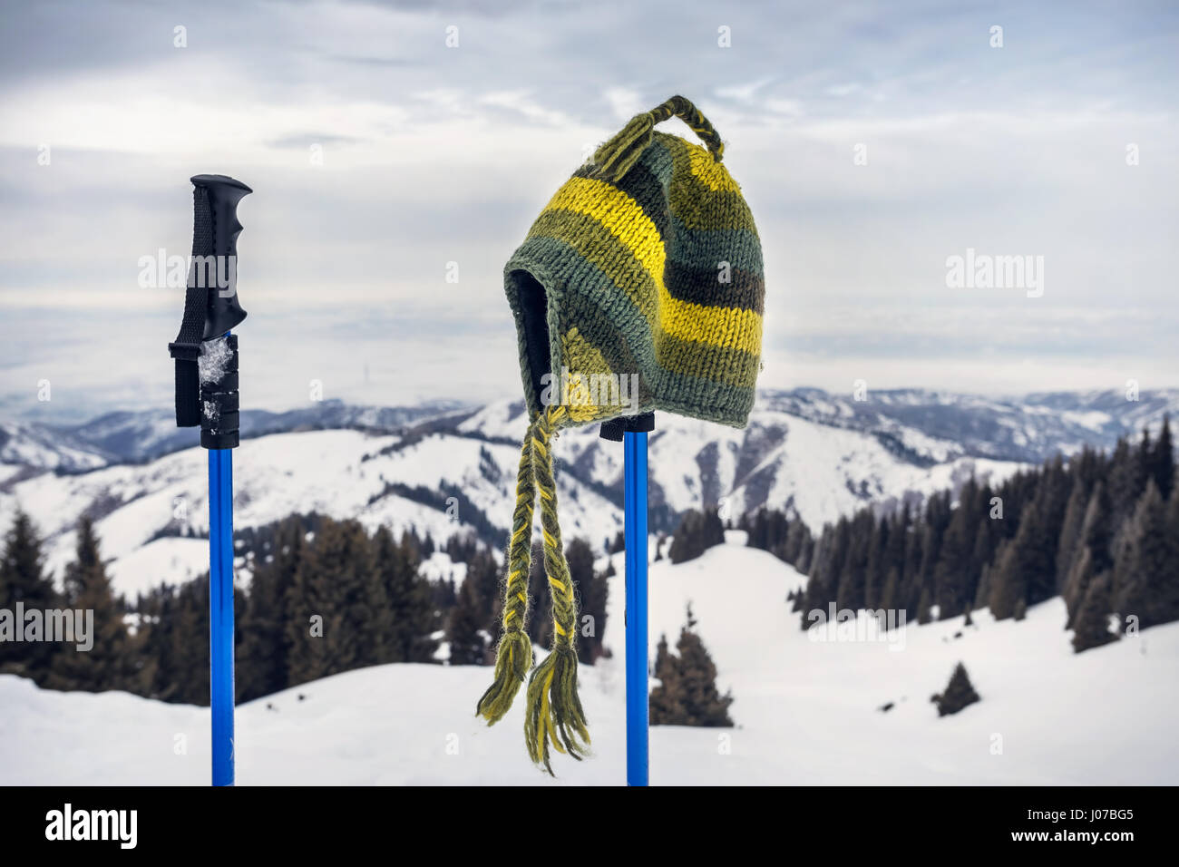 Fatti a mano dal cappello di lana di colore verde sul polo trekking in montagna. Concetto di tracking. Foto Stock