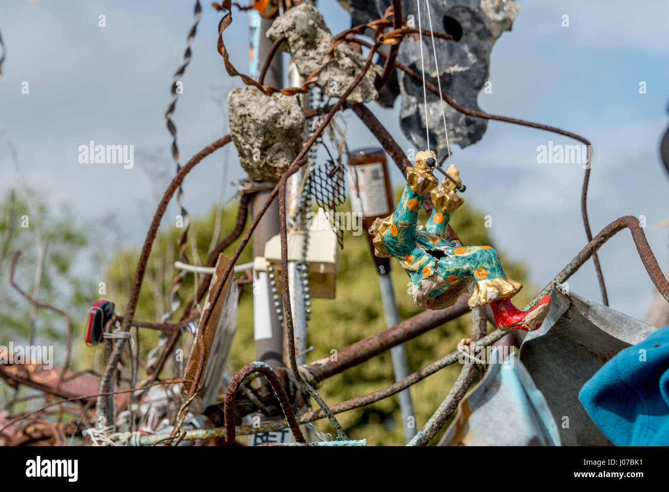 Dettagli di indesiderata arte scultura da riutilizzato garbage con decapitati clown figurina su trapezio, metallo arrugginito, bicicletta in corrispondenza del riflettore della lampadina di Albany, California Foto Stock