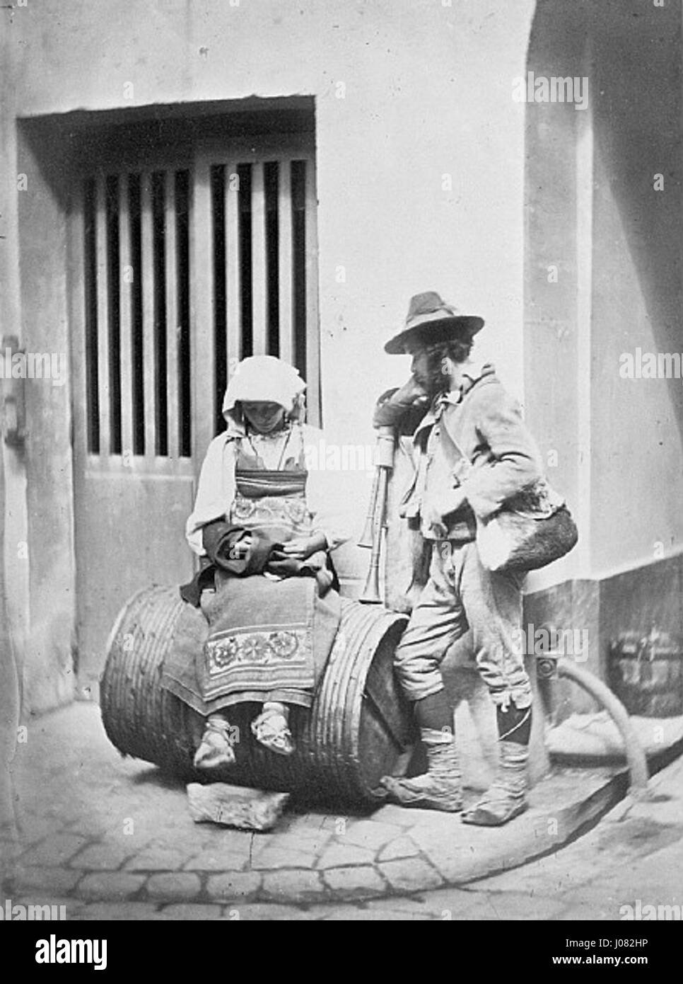I musicisti di strada italiani di Charles Nègre catturano l'atmosfera vivace delle strade di Parigi. La fotografia ritrae musicisti che si esibiscono, sullo sfondo iconico del Quai de Bourbon, mettendo in evidenza la capacità di Nègre di fondere la vita urbana con l'arte nel suo lavoro. Foto Stock