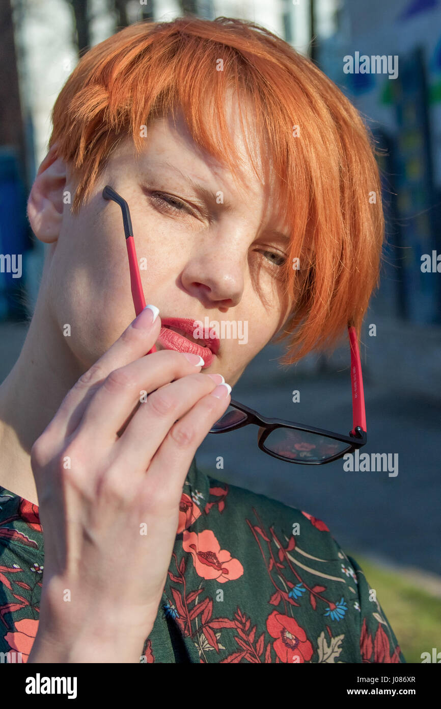 La ragazza con corti capelli rossi con gli occhiali ride Foto stock - Alamy