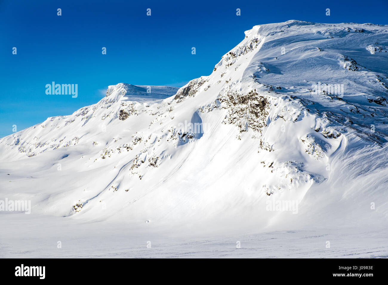 Coperta di neve montagna, cielo blu, Arctic Norvegia Foto Stock