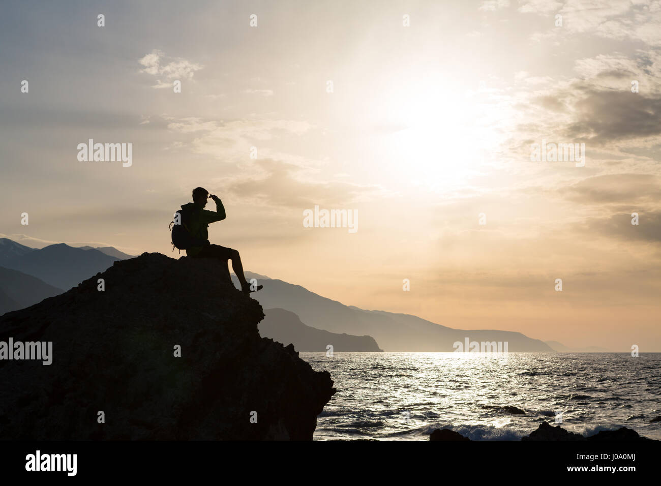 Escursionista o runner silhouette backpacker, un uomo in cerca di ispirazione paesaggio oceano e isole sul picco di montagna. Uomo realizzato celebrare la bella Foto Stock