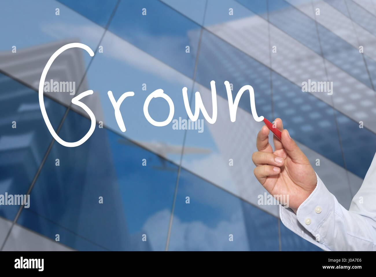 La mano di un imprenditore disegnati a mano una parola di cresciuto per presentare e applicando al vostro business. Foto Stock