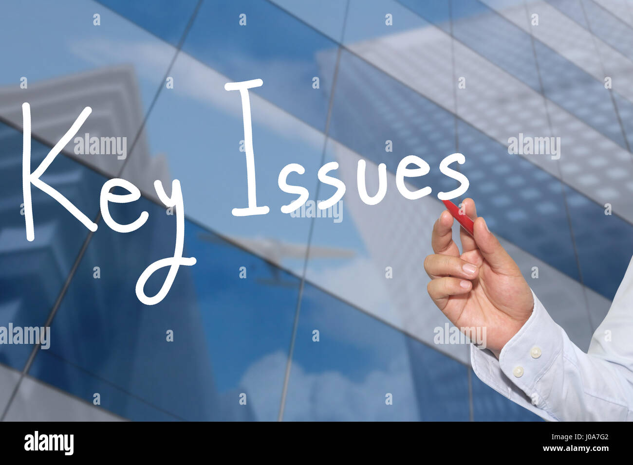 La mano di un imprenditore disegnati a mano una parola di questioni chiave per la presentazione e l'applicazione per il tuo business. Foto Stock