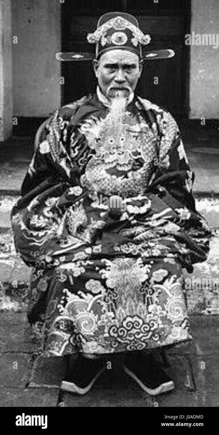 Questa opera vietnamita del 1933 cattura l'essenza della cultura tradizionale vietnamita con un'enfasi sui costumi e le scene locali. Il dipinto utilizza colori vivaci e pennellate dettagliate per rappresentare la vita rurale e le tradizioni popolari del tempo. Foto Stock