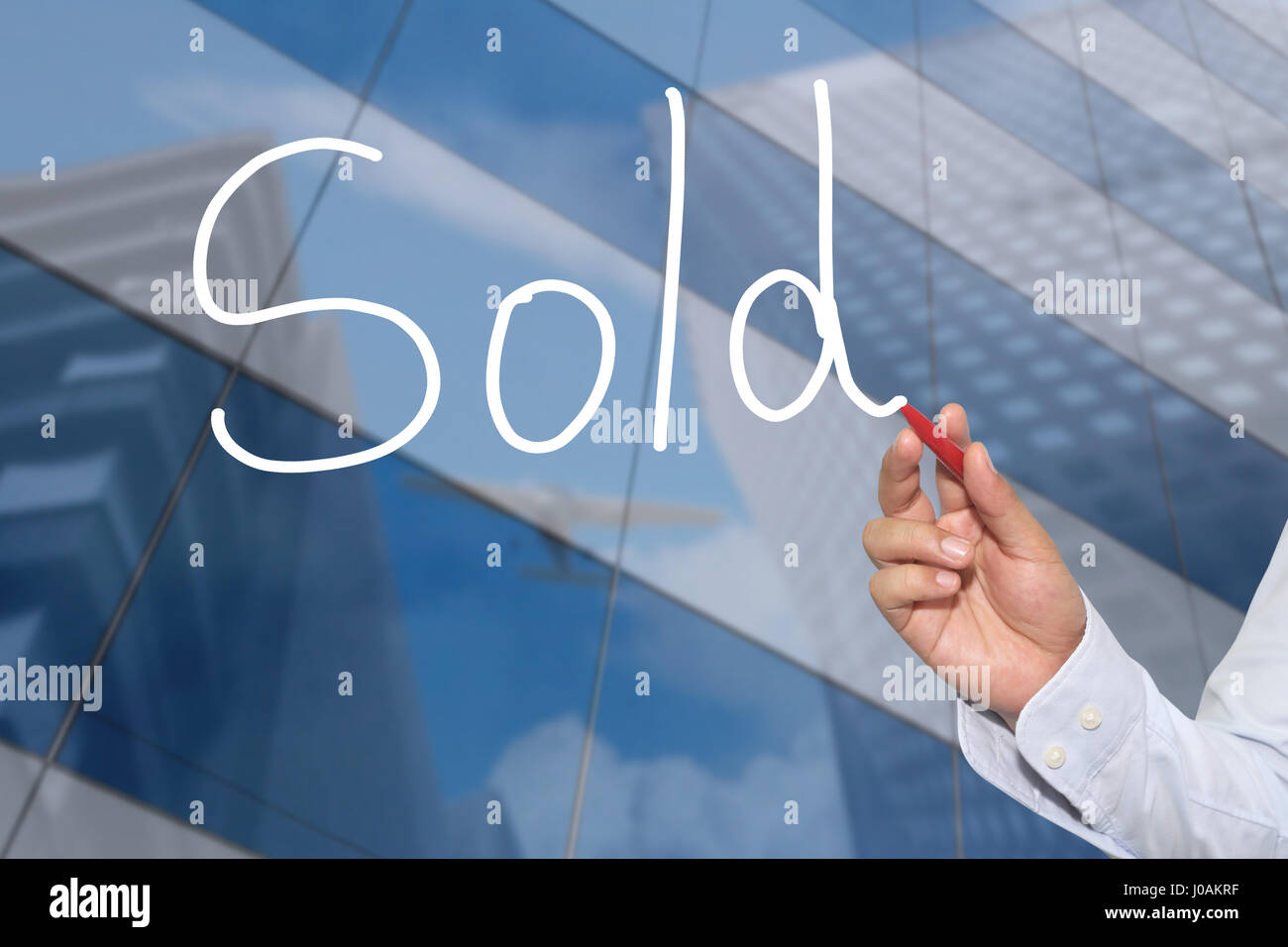 La mano di un imprenditore disegnati a mano una parola di venduti nel concetto di presentazione e di applicazione per il tuo business. Foto Stock