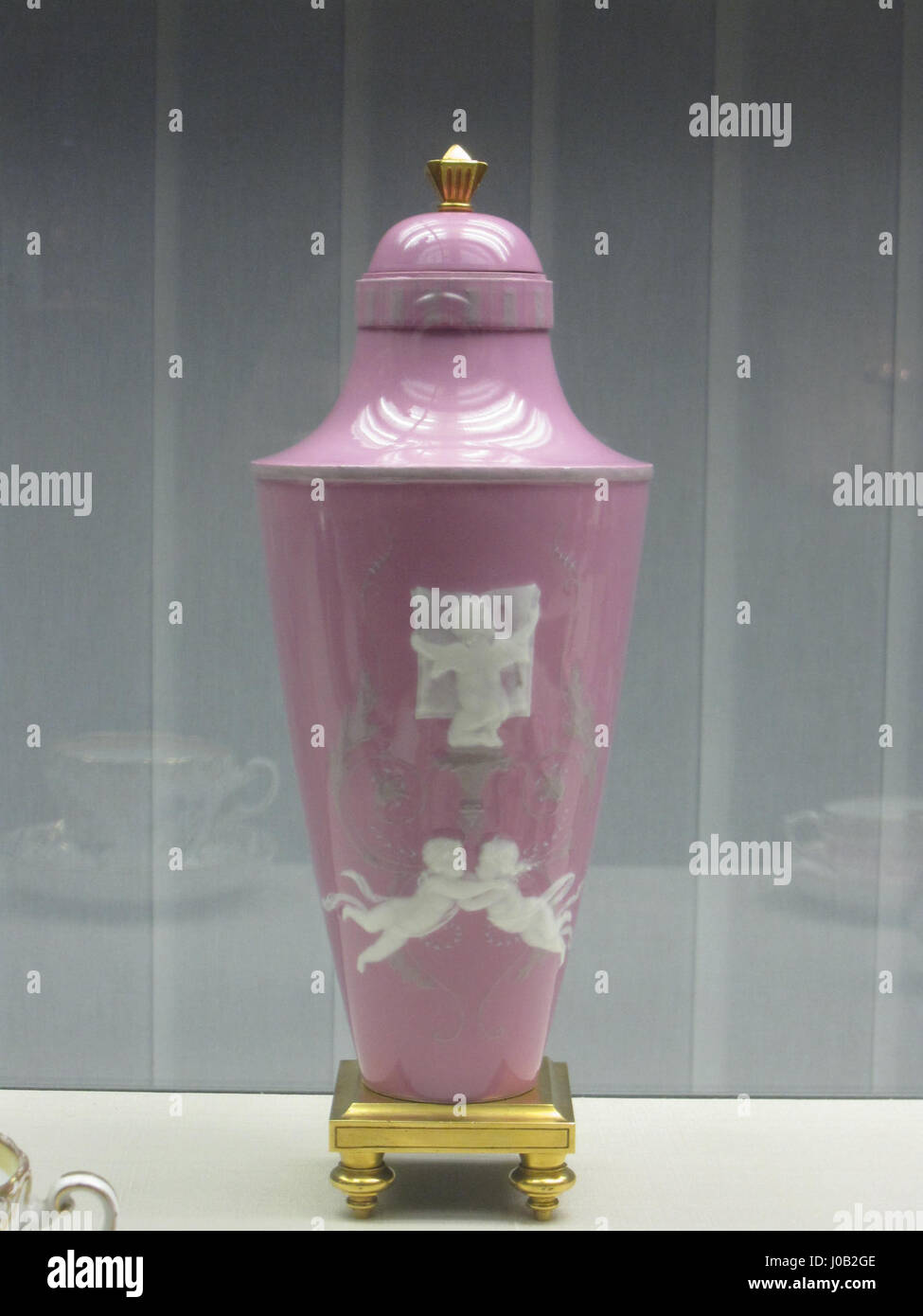 Questo vaso con coperchio presenta due putti scolpiti in pâte-sur-pâte, una tecnica che prevede l'applicazione di uno strato a rilievo sulla porcellana. L'opera d'arte mostra la raffinata maestria artigianale e gli elementi di design rococò del XVIII secolo, evidenziando gli intricati dettagli dei putti. Foto Stock