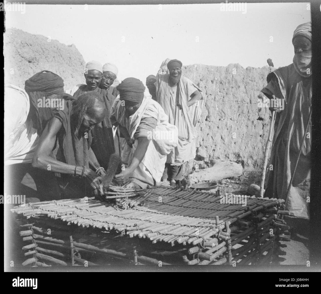 Questa fotografia mostra gli abitanti del Sudan settentrionale con un felino in gabbia, offrendo un'istantanea della vita quotidiana nella regione. L'immagine fornisce informazioni sulle pratiche culturali in Sudan. Foto Stock