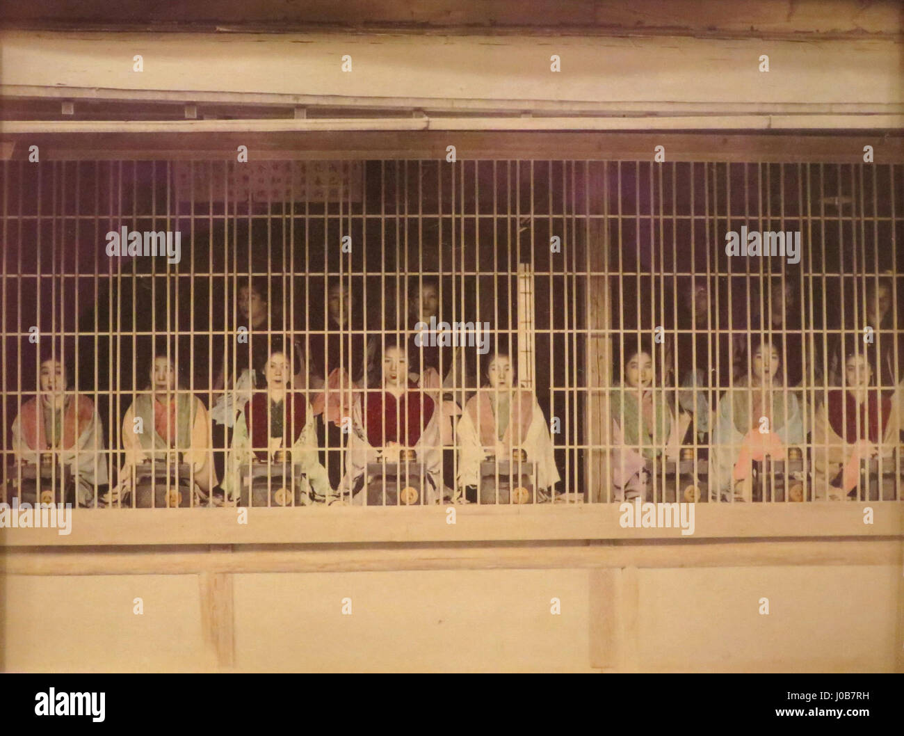 Questa stampa in argento all'albume, attribuita a Kusakabe Kimbei, raffigura il distretto di Yoshiwara in Giappone negli anni '1890 L'immagine raffigura donne del famoso quartiere a luci rosse, evidenziando il loro abbigliamento e le loro pose, colorate a mano per migliorare i dettagli e la vivacità della scena. Foto Stock