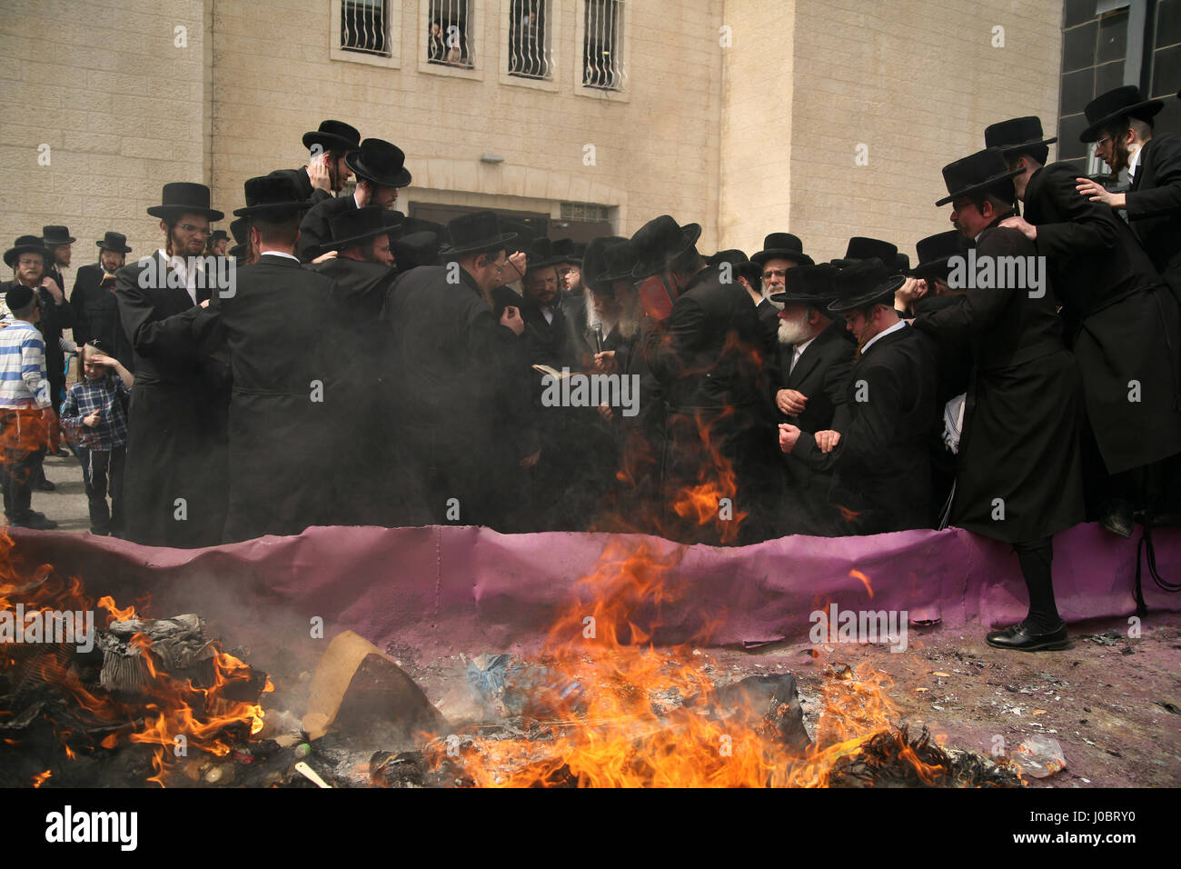 Ultra ortodosso uomini ebraica, Belz hasidim, raccogliere intorno a loro Rabbi, Yissachar Dov Rokeach durante la masterizzazione Chametz la mattina della vigilia di Pasqua Foto Stock
