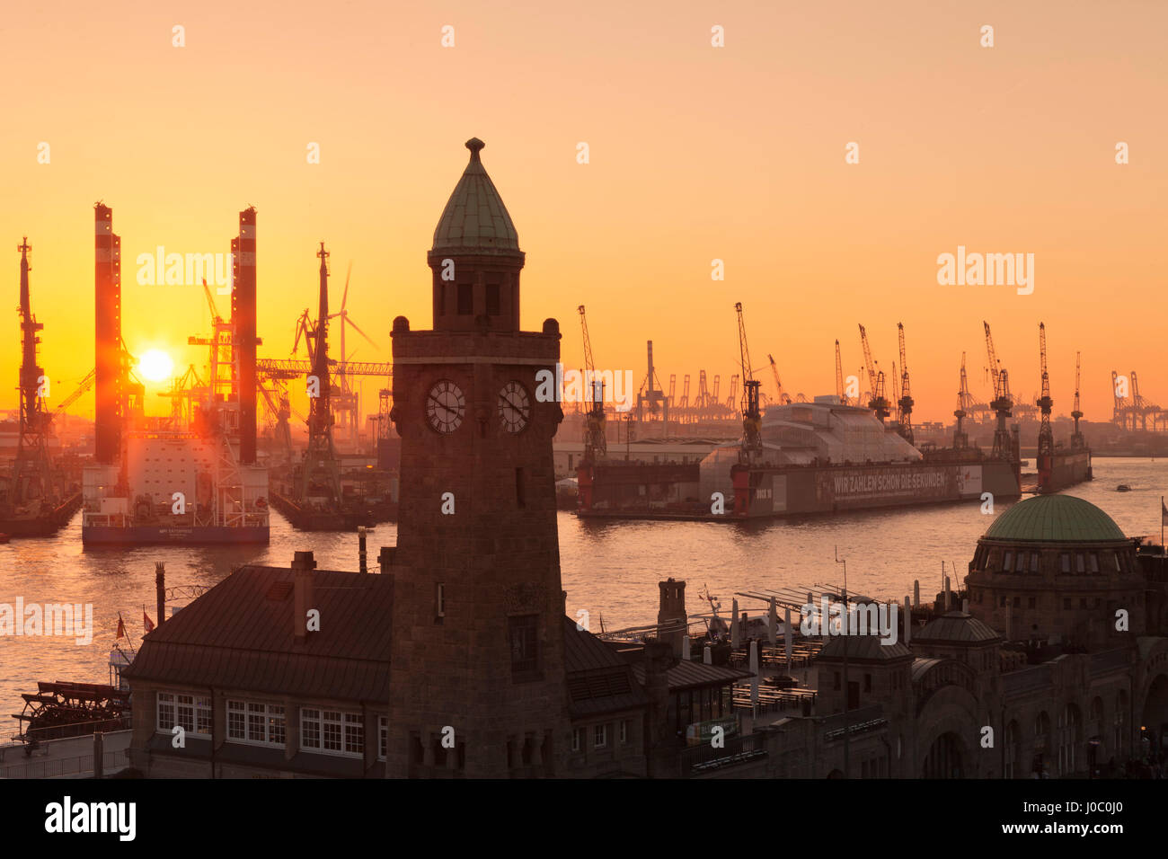 St Pauli Landungsbruecken pier contro il porto al tramonto, Amburgo, città anseatica, Germania Foto Stock