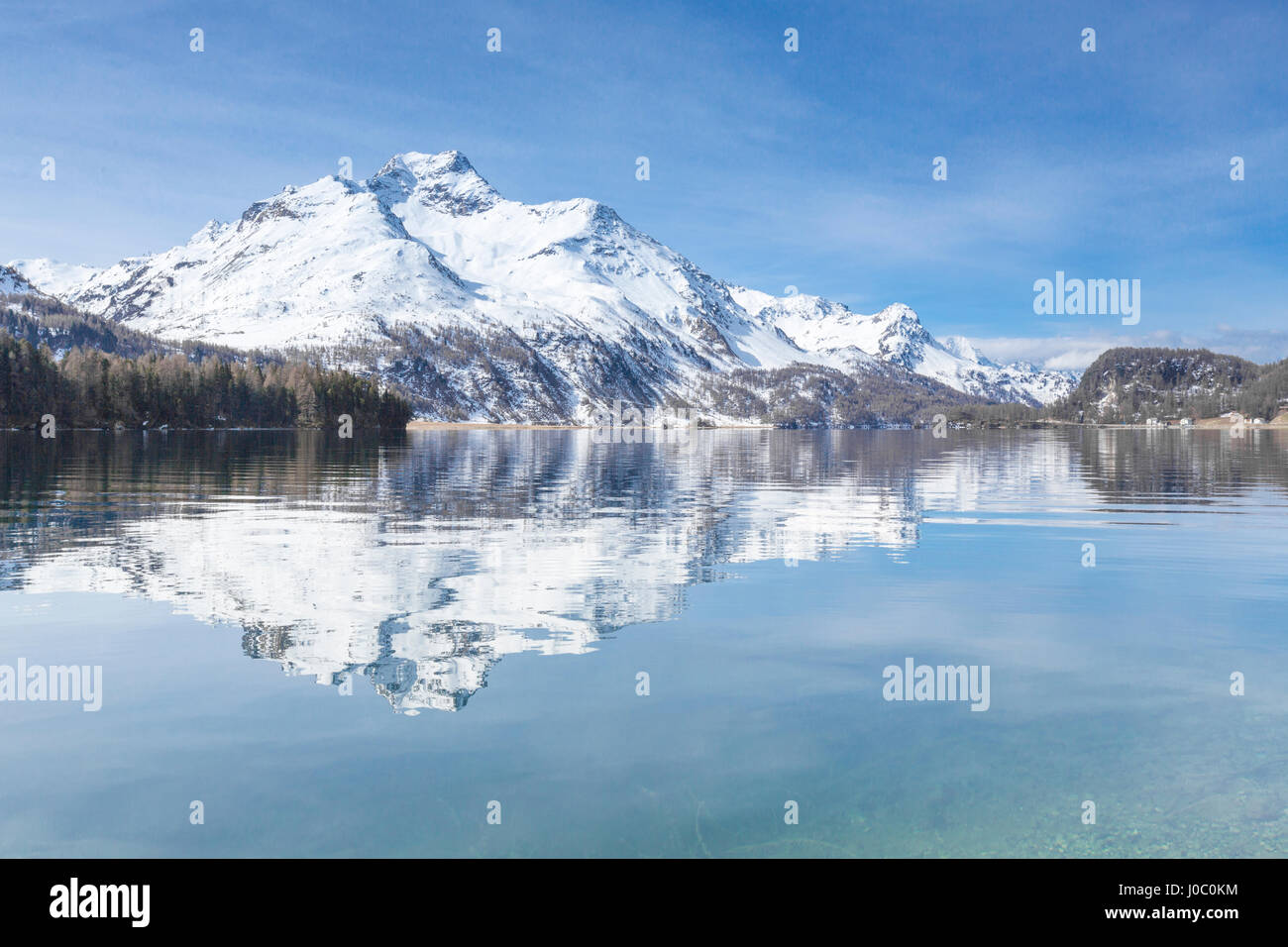 Vette innevate si riflette nelle limpide acque del lago di Sils, Maloja, Canton Grigioni, Engadina, Svizzera Foto Stock