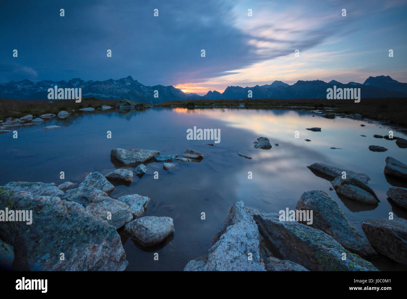 Le luci del tramonto riflesso nel lago alpino Muottas Muragl, Samedan, Canton Grigioni, Engadina, Svizzera Foto Stock