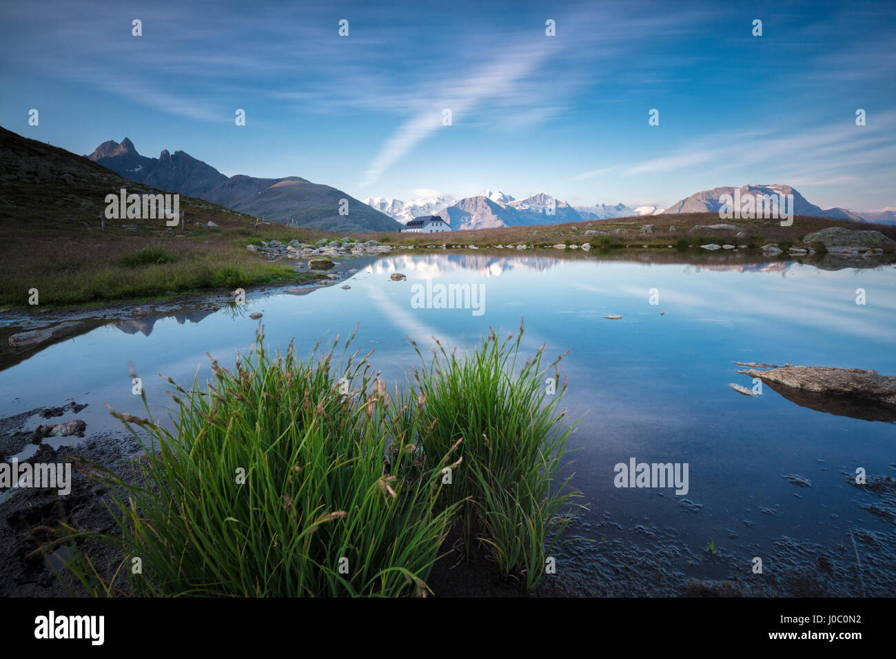 Il cielo chiaro è riflessa nell'azzurro lago alpino Muottas Muragl, Samedan, Canton Grigioni, Engadina, Svizzera Foto Stock