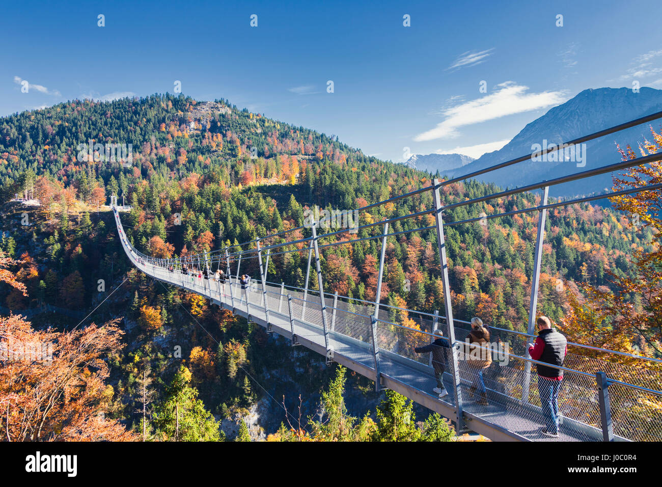 I turisti sulla sospensione ponte denominato Highline 179 incorniciato da boschi colorati in autunno, il Castello di Ehrenberg, Reutte, Austria Foto Stock