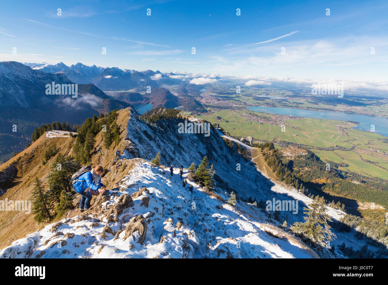 Gli alpinisti sulla ripida cresta ricoperta di neve nelle Alpi Ammergau, Tegelberg, Fussen, Baviera, Germania Foto Stock