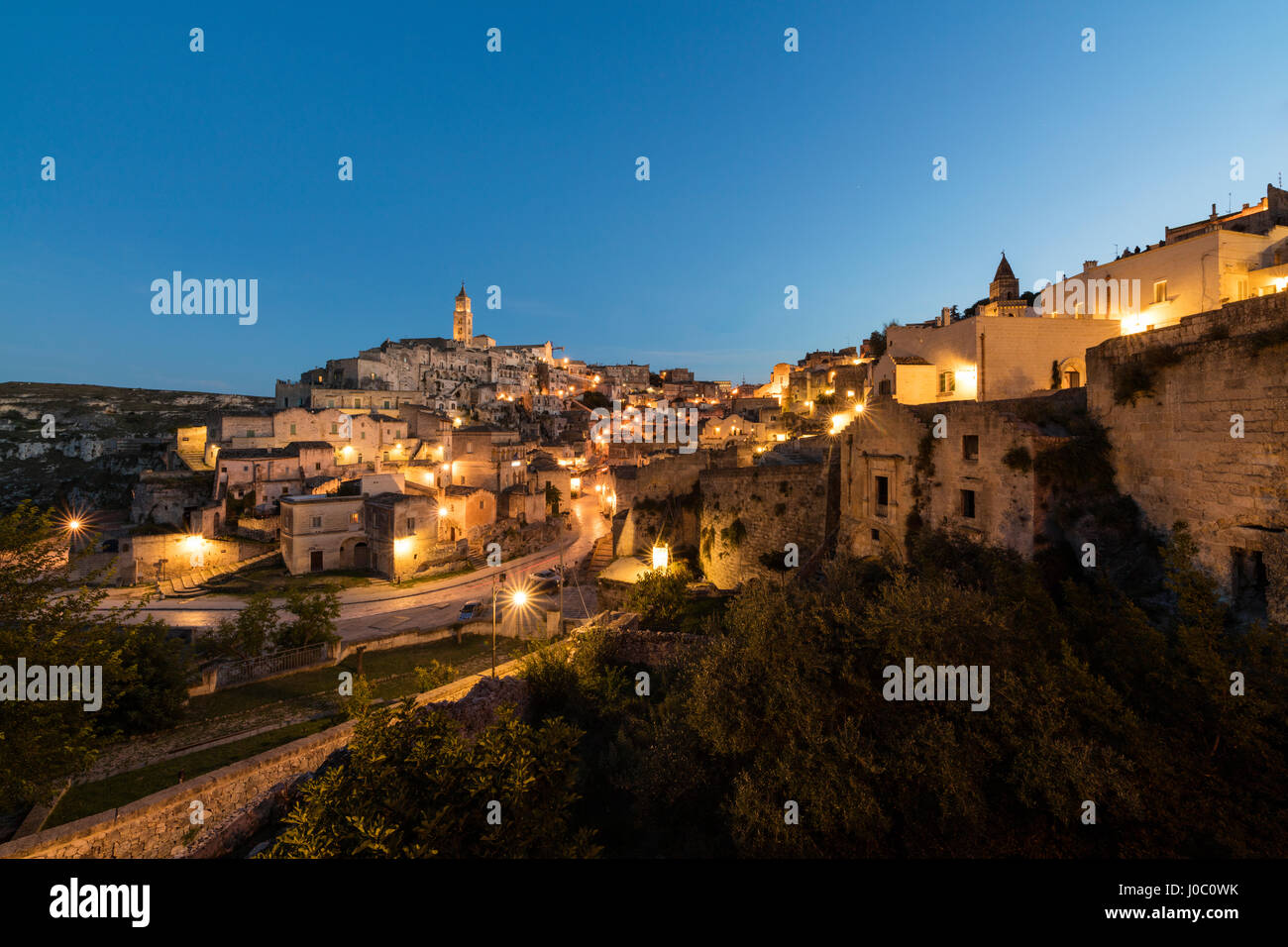 Il tramonto sulla città antica e centro storico chiamato Sassi, appollaiato sulla roccia sulla cima di una collina, Matera, Basilicata, Italia Foto Stock