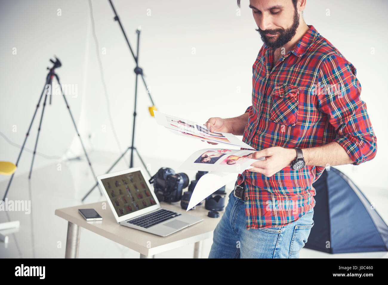 Fotografo maschio guardando le foto da Foto riprese in studio Foto Stock