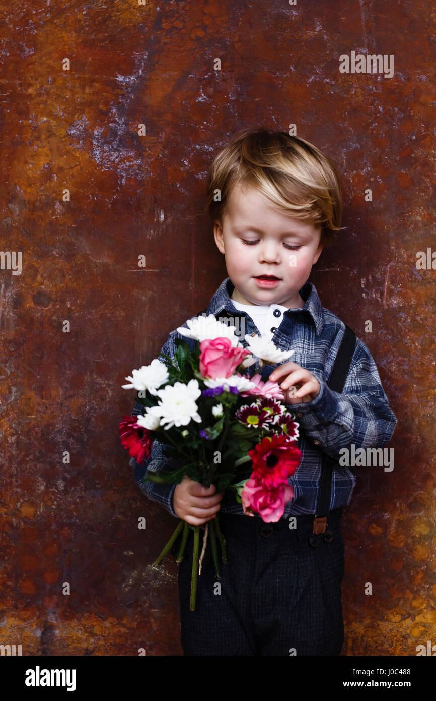 Ragazzo giovane azienda mazzo di fiori Foto Stock