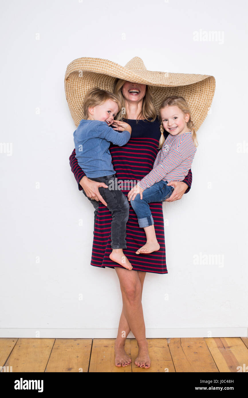 Donna che indossa sombrero, schermatura sia se stessa e due bambini Foto Stock