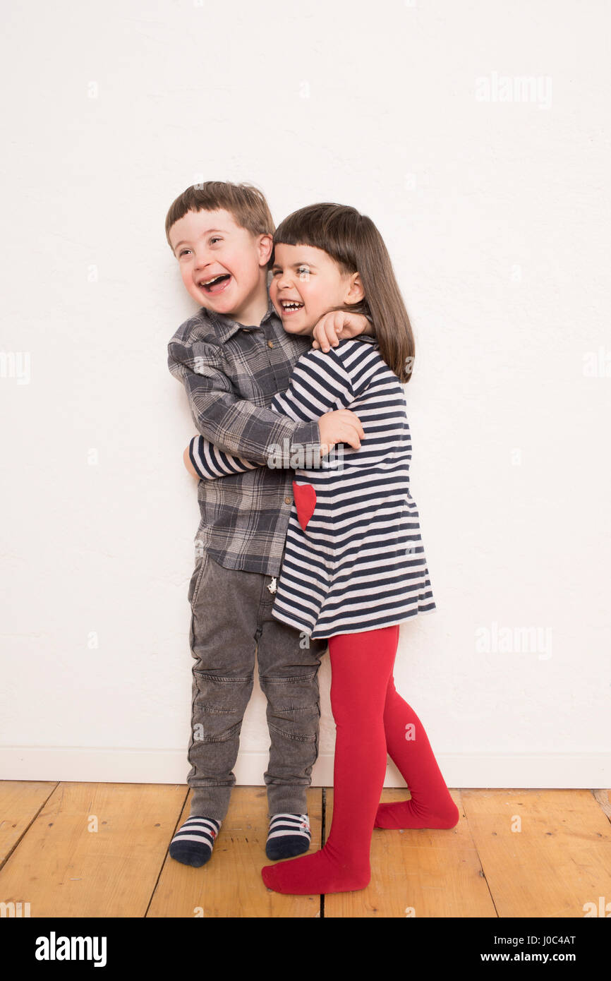 Ritratto di giovane ragazzo e una ragazza, avvolgente, ridendo Foto Stock