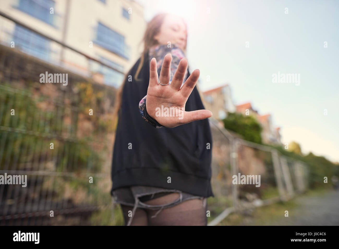 Giovane donna passeggiate all'aperto, tenendo la mano per telecamera vista posteriore, Bristol, Regno Unito Foto Stock