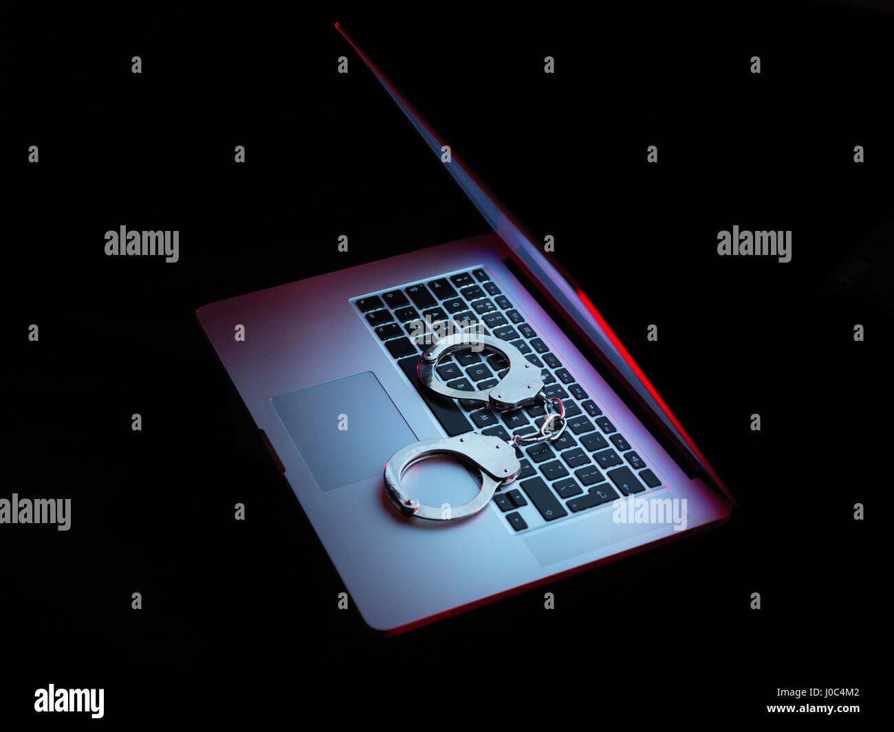 La sicurezza di rete, set di manette seduto sul computer portatile Foto Stock