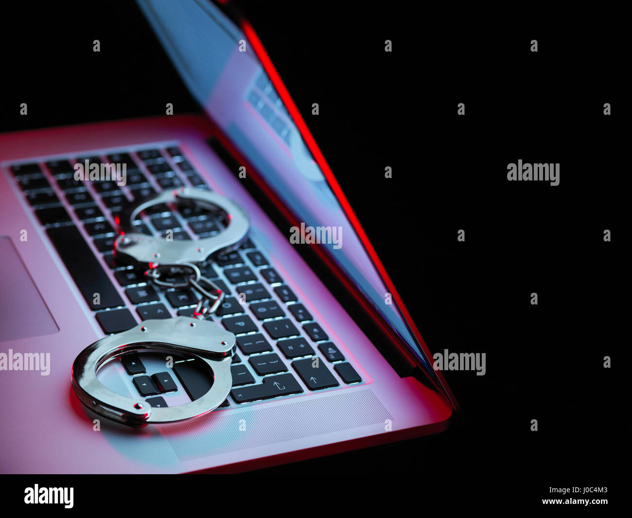 La sicurezza di rete, set di manette seduto sul computer portatile Foto Stock