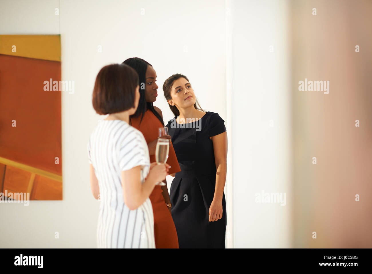 Tre donne guardando i dipinti ad olio alla galleria d'arte apertura Foto Stock