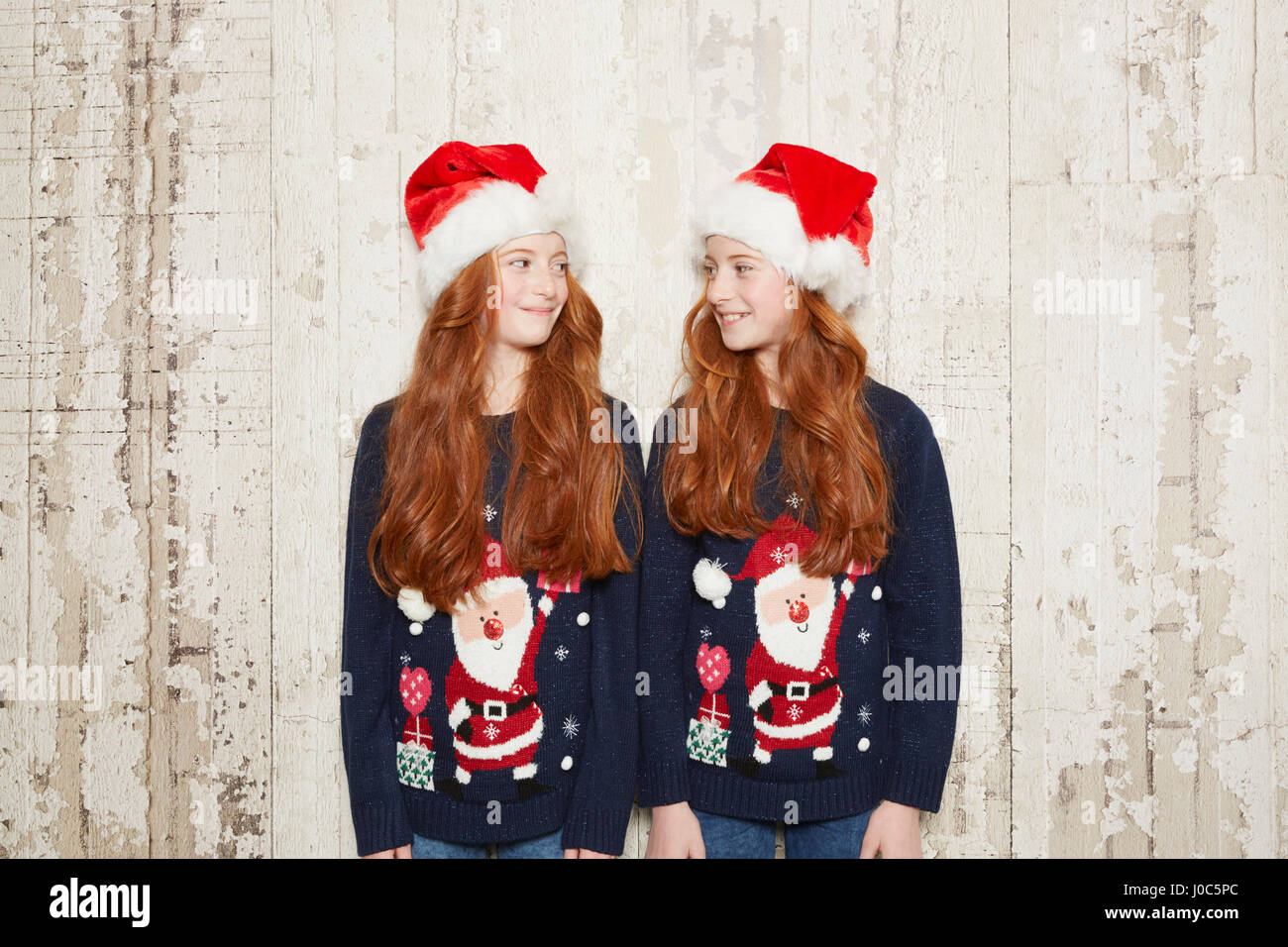 Ritratto di gemelle indossando i ponticelli di Natale e cappelli Foto Stock