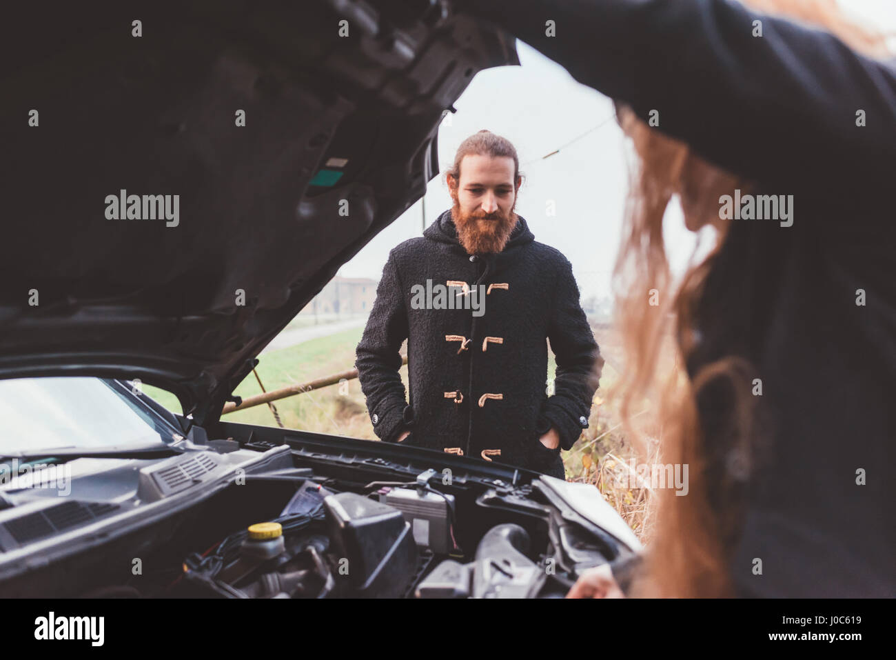 Coppia in cerca di auto a motore su strada Foto Stock