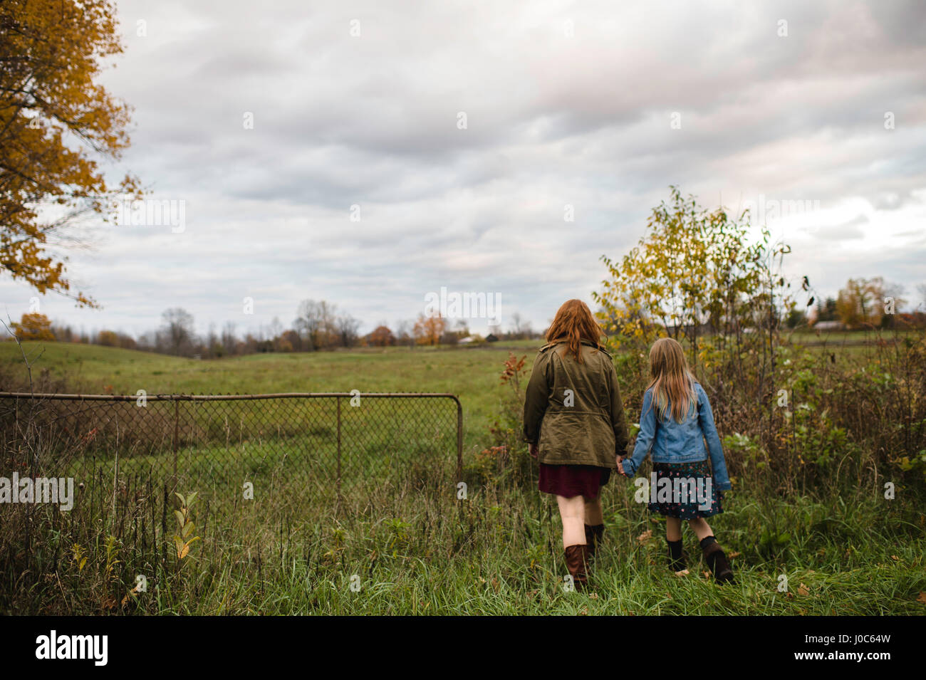 Madre e figlia per mano camminando nel prato, Lakefield, Ontario, Canada Foto Stock