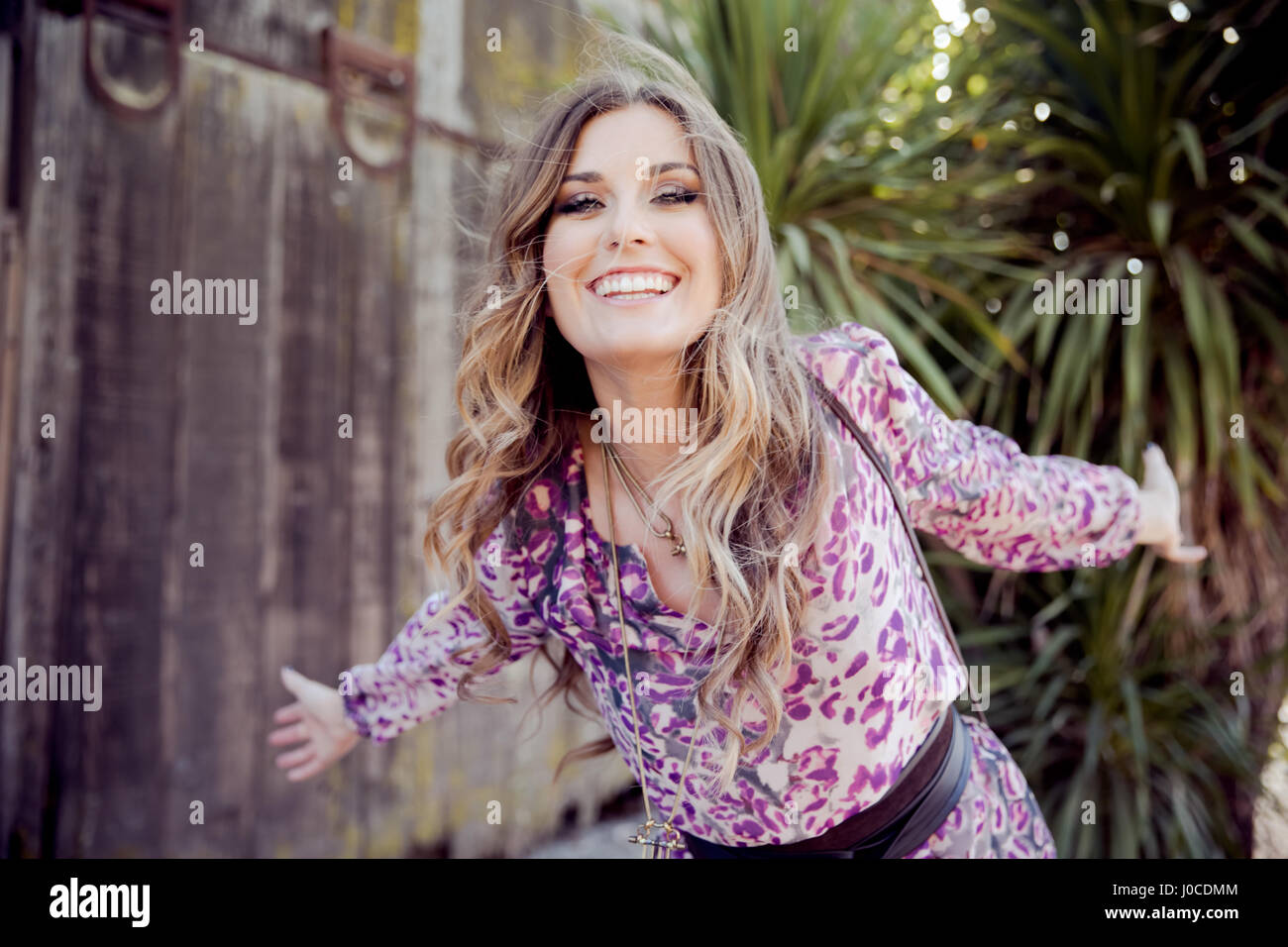 Ritratto di giovane donna con capelli lunghi biondi in giardino Foto Stock