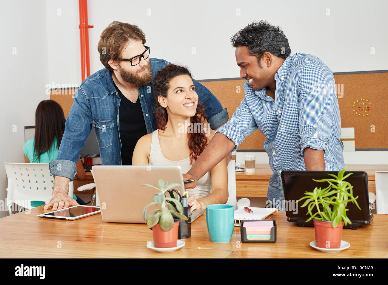 Fondatore e team con il computer portatile in startup consulting agency Foto Stock