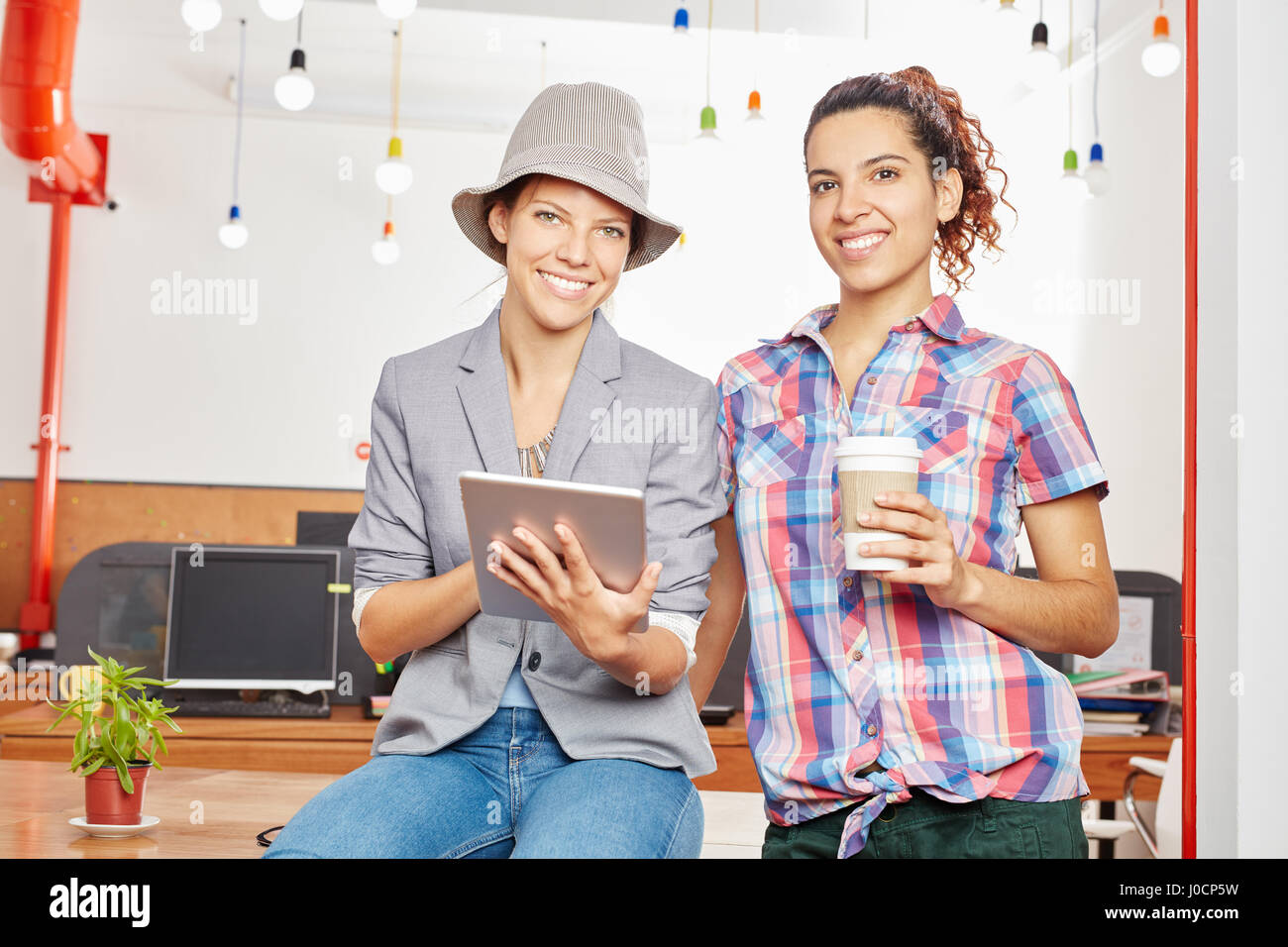 Due donne con computer tablet come creativo team di avvio Foto Stock
