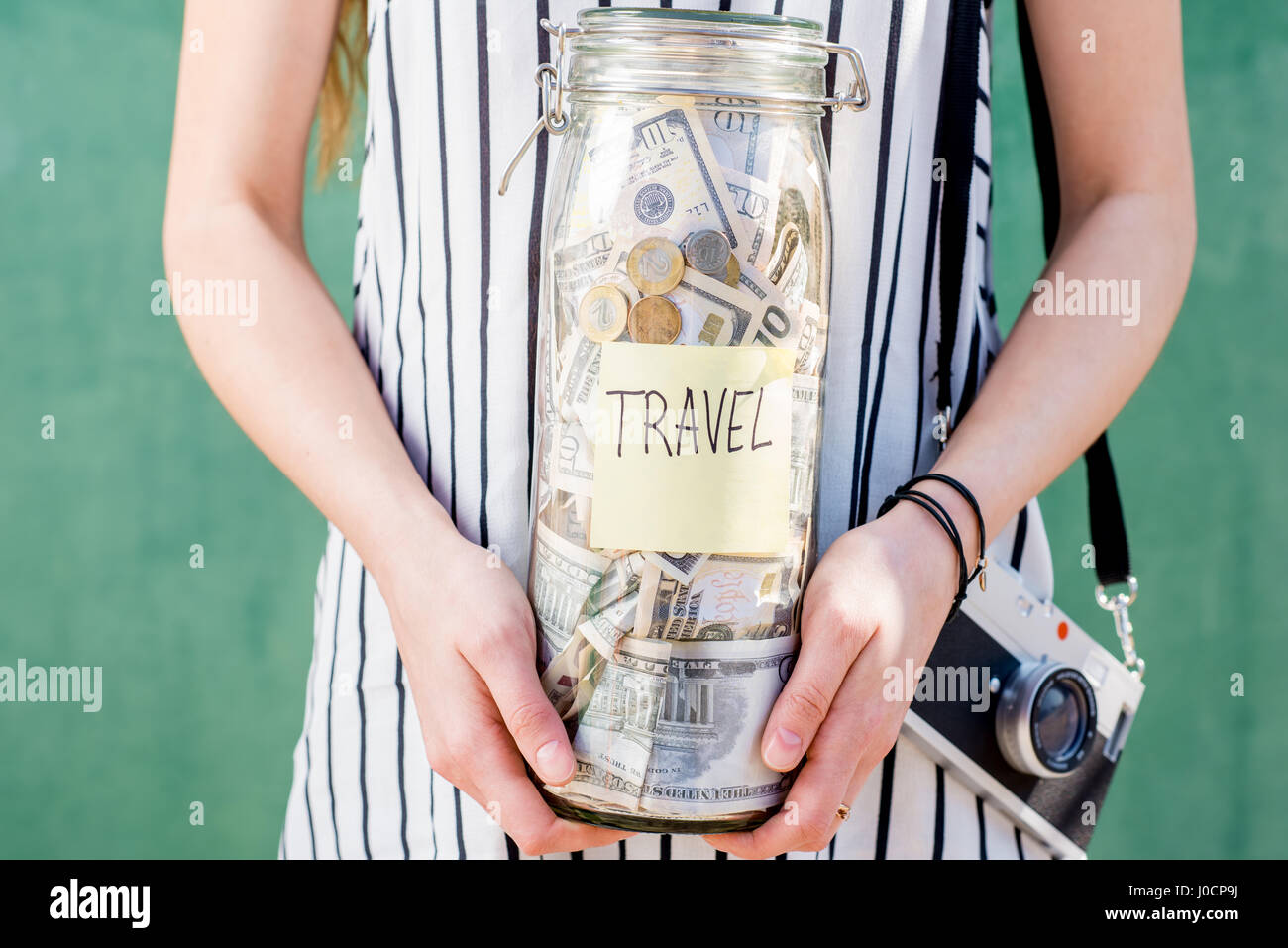 Donna che mantiene il vaso pieno di denaro per le vacanze estive Foto Stock
