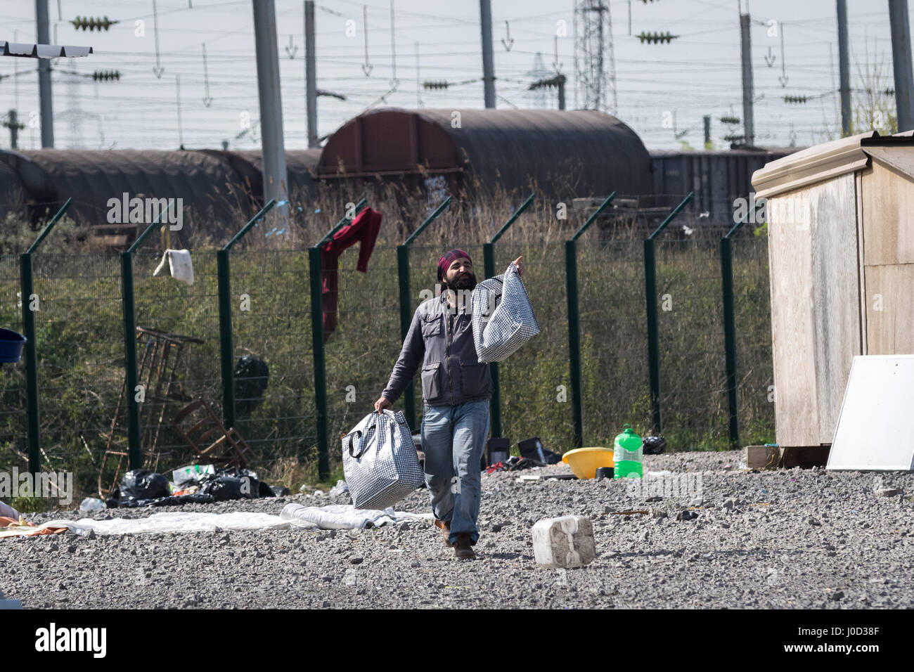 Grande Synthe, Francia. Xi Apr, 2017. grande-Synthe postumi - 11/04/2017 - Francia/Nord (regione)/Grande Synthe - All indomani della rissa tra curdi iracheni e afgani, il Grande Synthe migranti' accampamento è parzialmente distrutta dalle fiamme. Non vi è nulla di sinistra ma gli affari in ceneri o abbandonati. Tre i rifugiati sono in attesa del momento giusto per entrare nel campo di recuperare i loro averi. - Julien Mattia/Le Pictorium credito: Le Pictorium/Alamy Live News Foto Stock