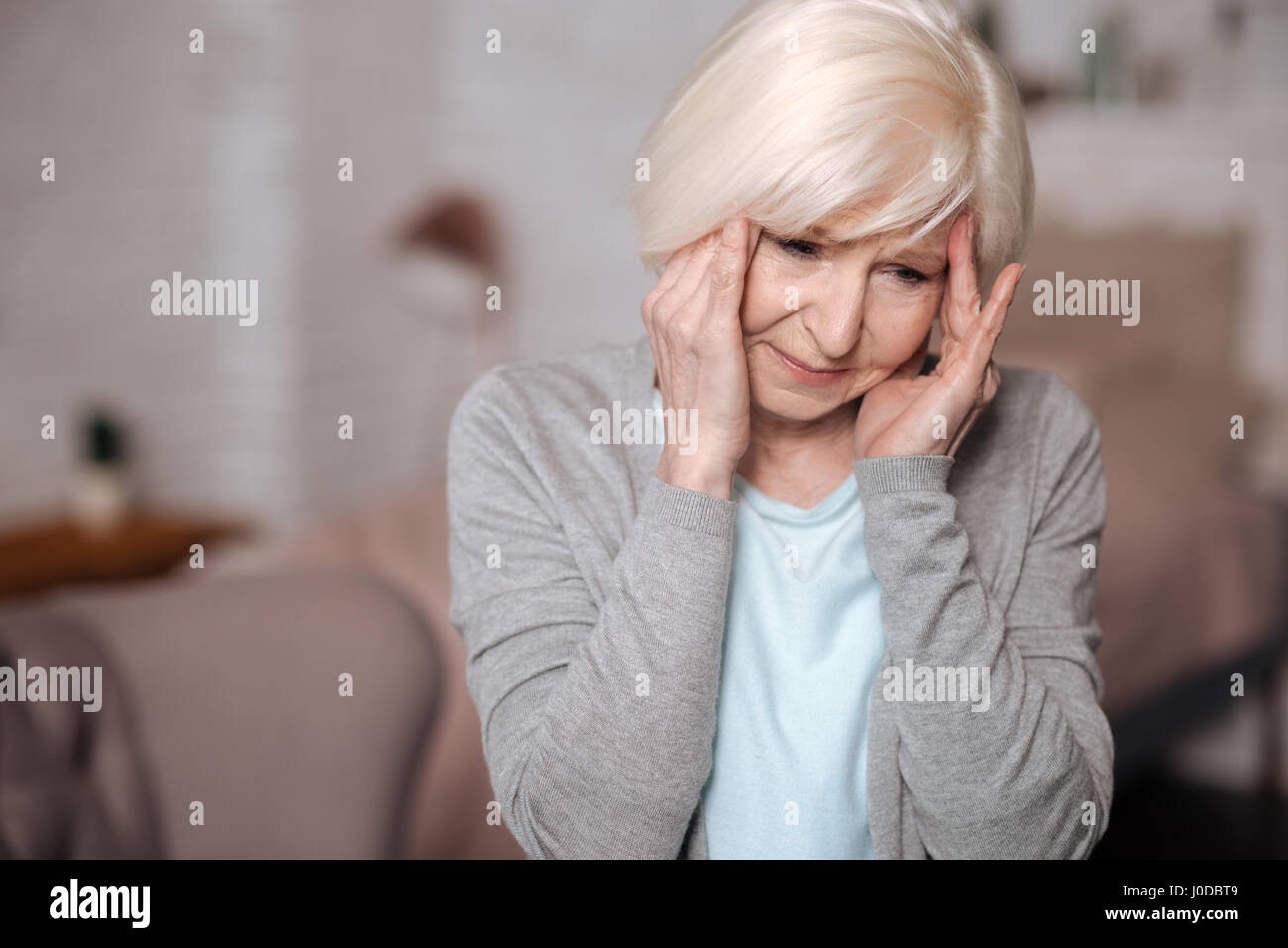 Oh, non ancora. Close-up ritratto di molto triste donna anziana toccando i suoi templi a causa del terribile mal di testa. Foto Stock