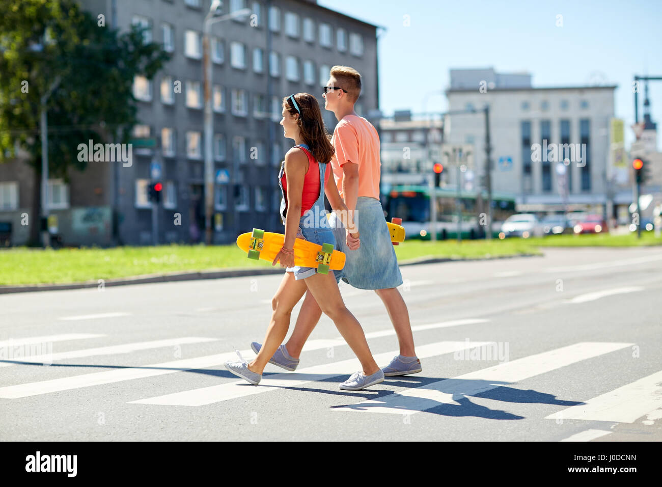 Giovane adolescente con skateboard su city crosswalk Foto Stock