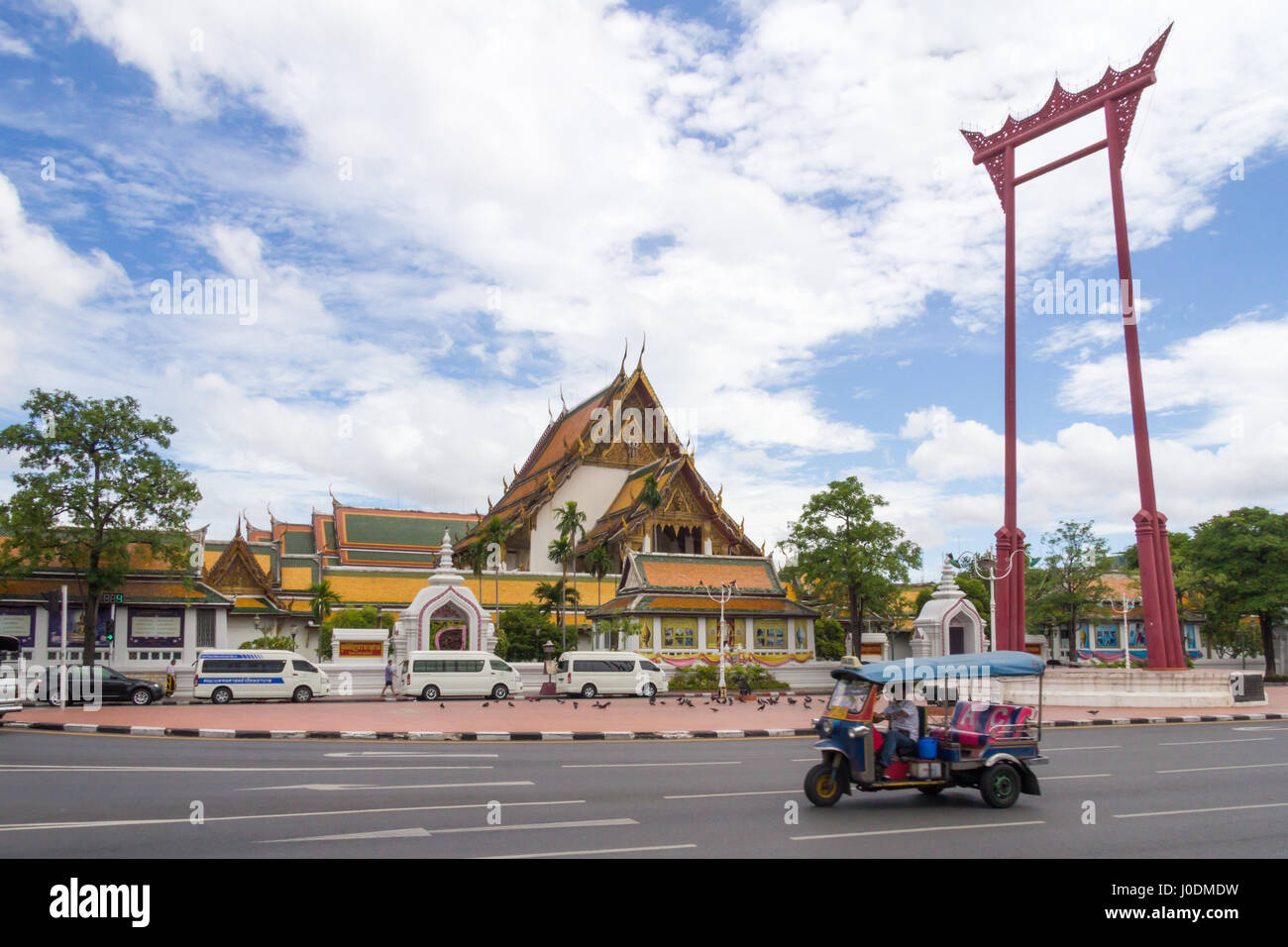 Atuk tuk rigidi passato il gigante Swing con il Wat Suthat in background, Bangkok, Thailandia Foto Stock