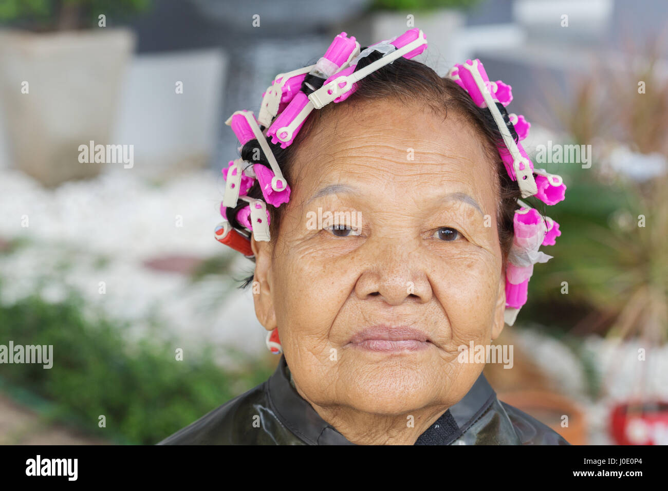 Asian senior donna con rullo per capelli Foto Stock