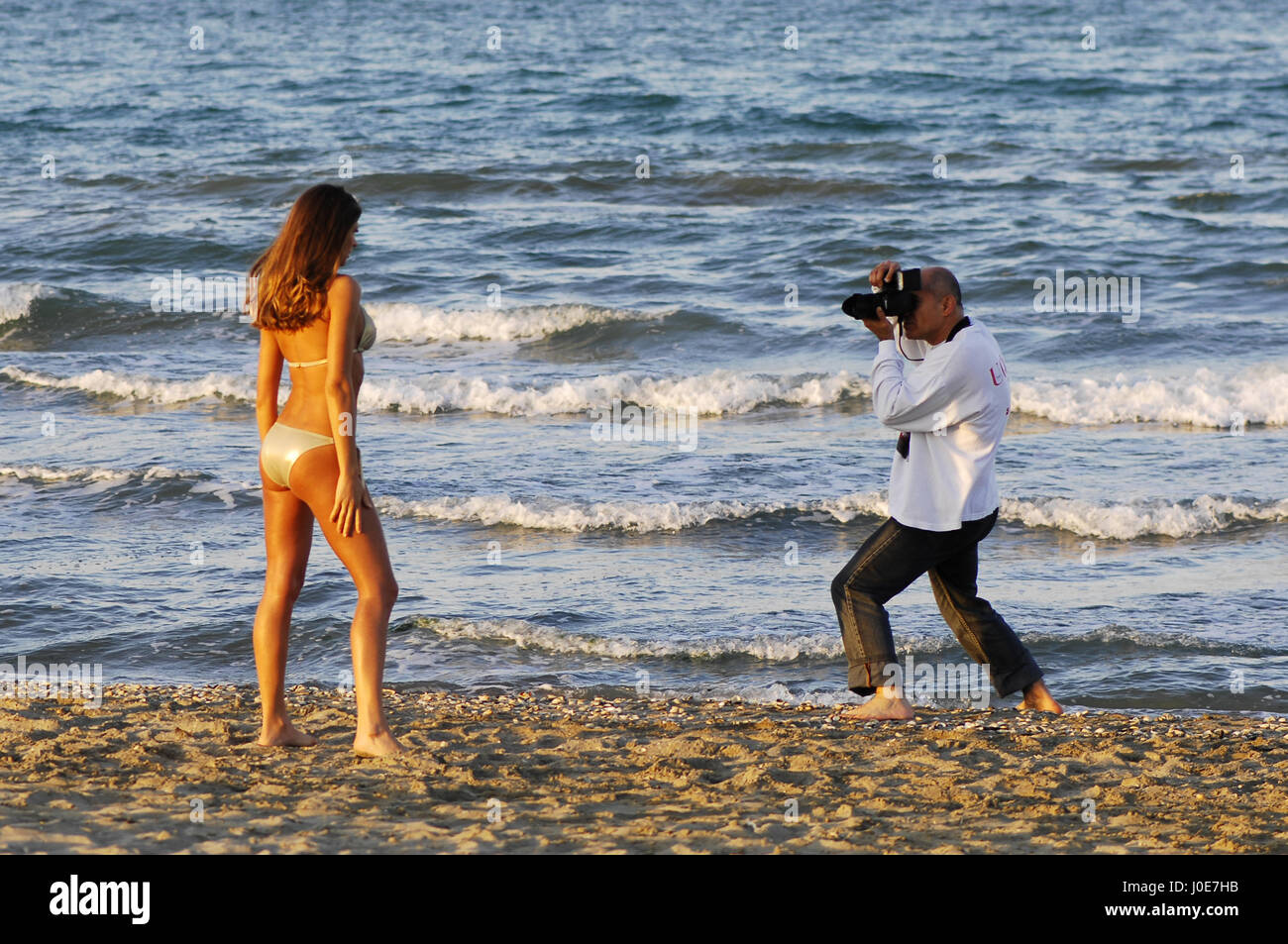 Fotografo con il modello sulla spiaggia: shooting backstage Foto Stock