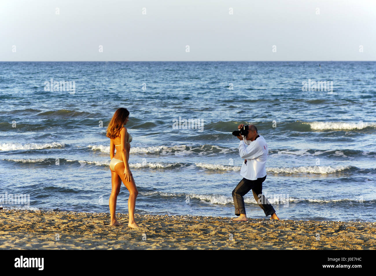 Fotografo con il modello sulla spiaggia: shooting backstage Foto Stock