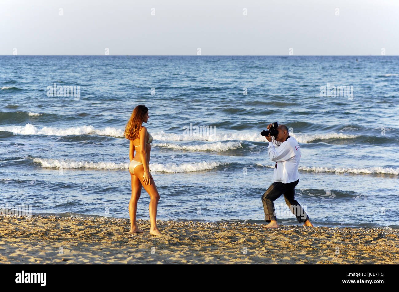 Fotografo con il modello sulla spiaggia: shooting backstage Foto Stock