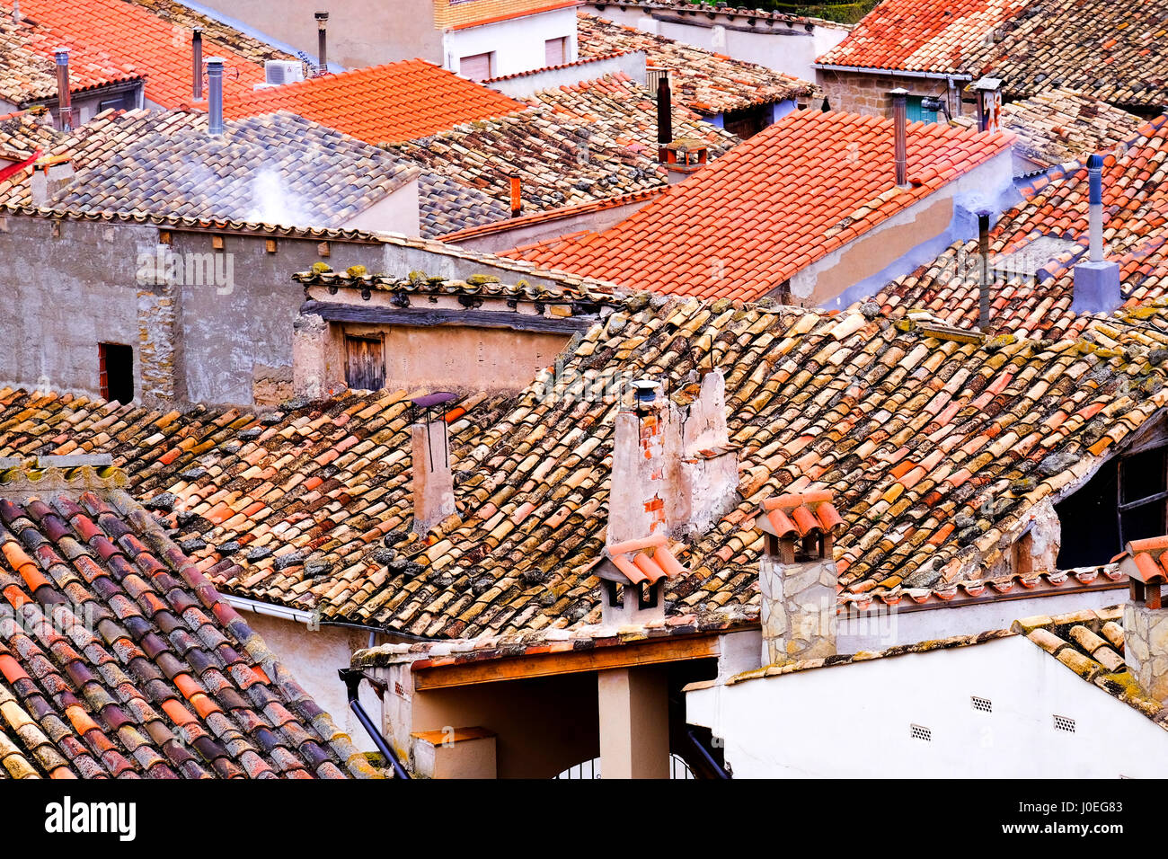 I tetti di un certo numero di case di spagnolo in un villaggio con pantiles e camini Foto Stock