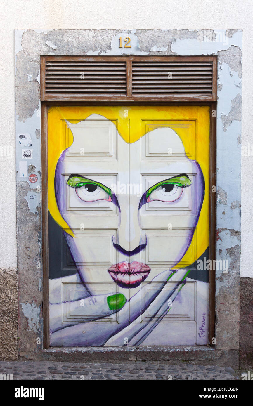 Una pittura di un volto di donna; fa parte di una serie di porte dipinte dall' "arte di aprire porte' progetto, Funchal, Madeira Foto Stock