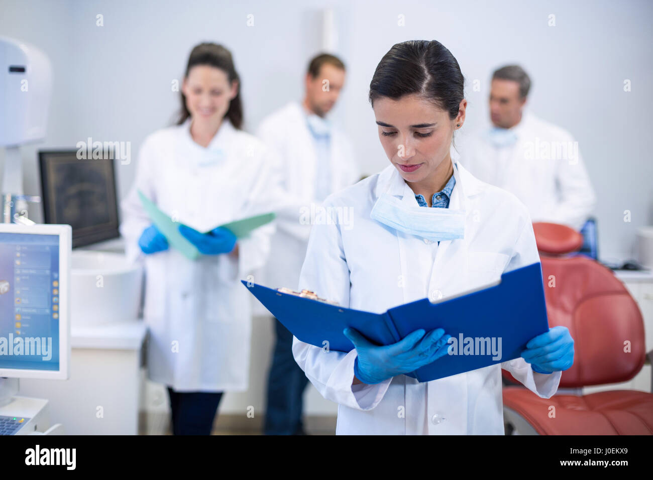 Attento dentista guardando i report in clinica dentale Foto Stock