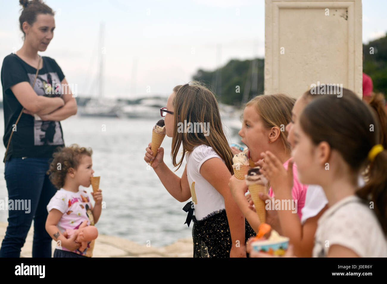 Un gruppo di ragazze a mangiare il gelato durante un'escursione. La citta di Hvar, Croazia Foto Stock